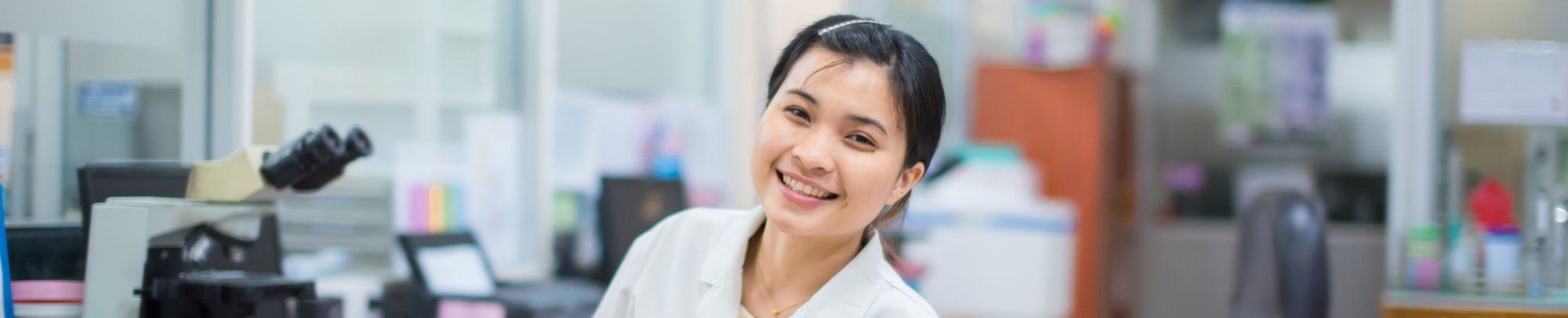 Researcher sitting in the lab by a microscope